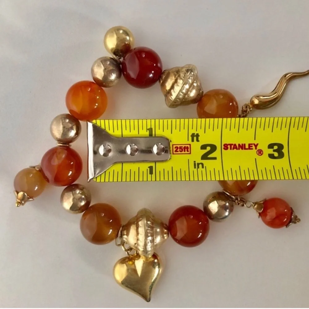 Handcrafted artisan amber tone stones paired with gold heart beaded charms brace